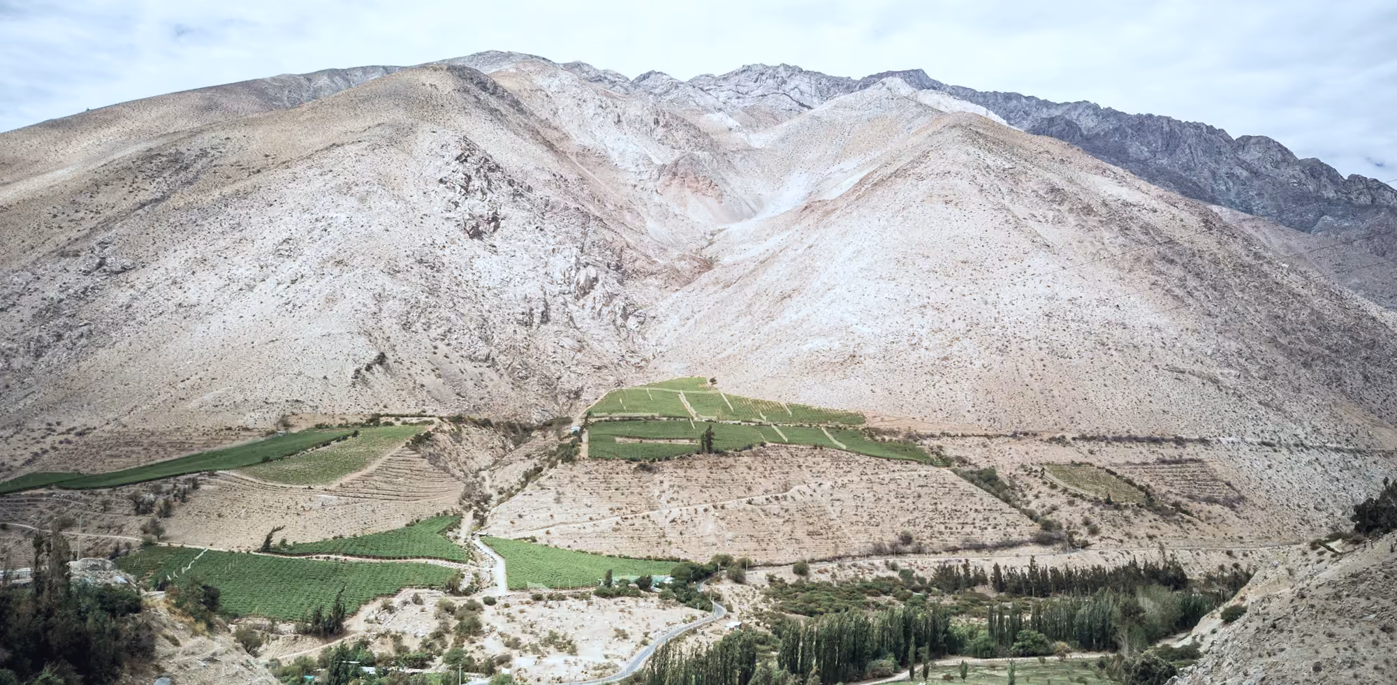 Cerros áridos del valle del Elqui con terrazas de cultivo verdes en la ladera baja